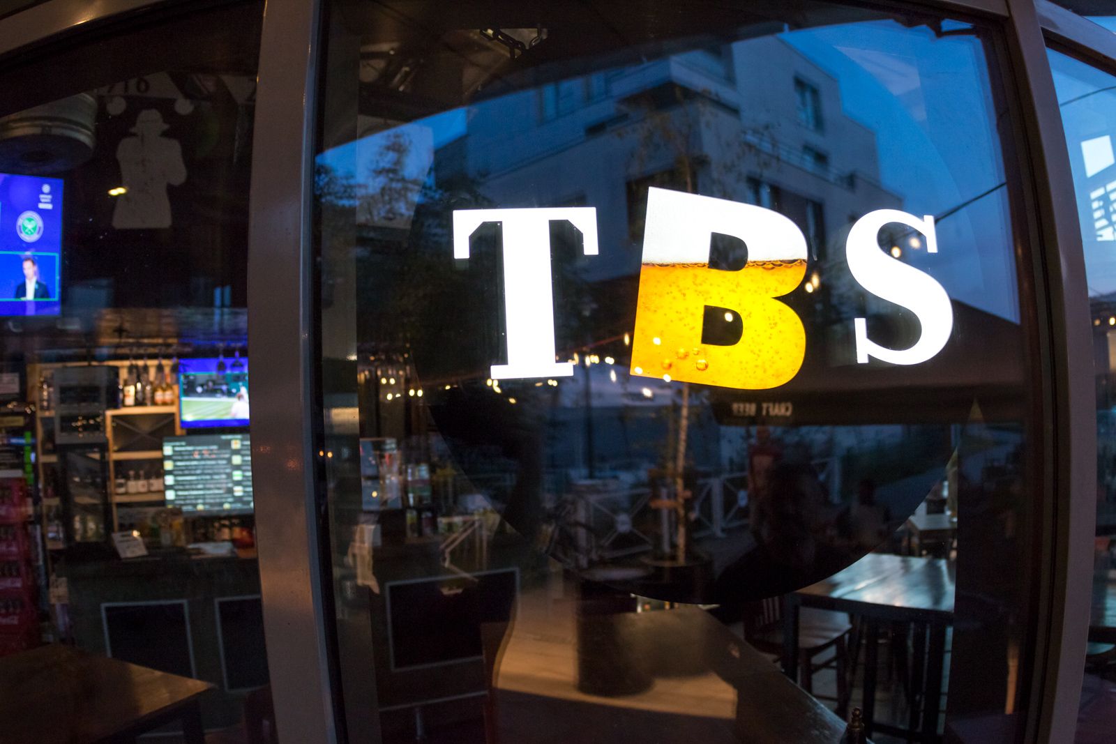 Logo TBS z literą B wypełnioną piwem na szybie lokalu The Beer Store